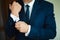 Grooms morning preparation, handsome groom getting dressed and preparing for the wedding, in dark blue suit