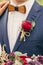 Grooms with wooden bow-tie and red rose boutonniere on wedding