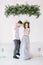 Groomsman and bridesmaid dressed in grey blue dress dancing in white room with wedding decorations