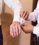 Groomsman helps groom to put on cufflinks close-up