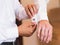 Groomsman helps groom to put on cufflinks close-up