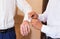 Groomsman helps groom to put on cufflinks close-up