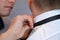 Groomsmen helping groom to put on his bow tie