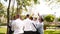 Groomsmen toss groom in the air. Man flexing and having fun with best friends on wedding day in park. Cheerful guys