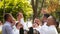 Groomsmen toss groom in the air. Man flexing and having fun with best friends on wedding day in park. Cheerful guys