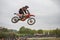 Gross Schwiesow, Germany - March 01,2019 - Motocross racer making a stunt and jumps in the air over a sand hill