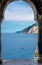 Grotta di Lord Byron, coast with rock cliff and boat through arch colonnade Church San Pietro, Portovenere
