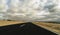 Ground beautiful view of long way straight asphalt road and blue clouds sky in background - concept of drive and travel with