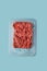 Ground beef or cultured artificial meat isolated on laboratory blue background