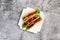 Ground beef tacos with lettuce, tomatoes, pink onions on a white square  plate on a dark background