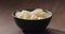 ground black pepper fall on potato chips fall in black bowl on walnut table