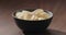 ground black pepper fall on potato chips fall in black bowl on walnut table