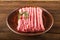 Ground chicken with a sprig of rosemary on a wooden plate on a textural table. Turkey mince raw close-up and copy space