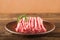 Ground chicken with a sprig of rosemary on a wooden plate on a textural table. Turkey mince raw close-up and copy space