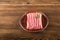 Ground chicken with a sprig of rosemary on a wooden plate on a textural table. Turkey mince raw close-up and copy space