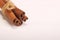 Ground cinnamon, cinnamon sticks, tied with jute hempen rope on wooden white background, selective soft focus