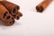 Ground cinnamon, cinnamon sticks, tied with jute hempen rope on wooden white background, selective soft focus