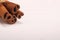 Ground cinnamon, cinnamon sticks, tied with jute hempen rope on wooden white background, selective soft focus