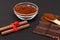 Ground coffee and chocolate on the black background and fresh piled coffee on wooden spoon