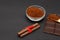 Ground coffee and chocolate on the black background and fresh piled coffee on wooden spoon