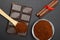 Ground coffee and chocolate on the black background and fresh piled coffee on wooden spoon