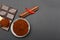 Ground coffee and chocolate on the black background and fresh piled coffee on wooden spoon