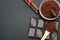 Ground coffee and chocolate on the black background and fresh piled coffee on wooden spoon