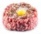 Ground cutlet or raw hamburger with quail egg yolk and seasonings on white background. Close-up