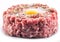 Ground cutlet or raw hamburger with quail egg yolk and seasonings on white background. Close-up