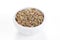 Ground dried Basil in a bowl on white background.