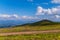 Ground, dusty road going through the green, succulent grass in the mountains