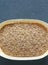 Ground flaxseed in a natural wooden bowl on a slate background