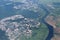 On the ground, houses, forests, greenery, roads, fields are visible in the summer from the window of the aircraft from a height.