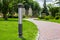 Ground iron lantern on a winding curved pedestrian walkway.