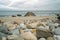 Ground level shot of boulders on a beach, and a rocky jetty pointing toward the horizon, Block Island, RI