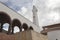 Ground view of colombian guatavita town clock tower with brick arc structure and blue cloudy sky