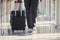 Grounded view of male passenger in elegant formal clothes is in the airport hall walking with baggage