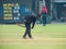 Groundsman sweeping away dirt from cricket pitch.