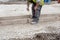 Groundworker making shutter for concrete to form base for kerb using scaffold boards and steel road pins during new road