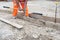 Groundworker making shutter for concrete to form base for kerb using scaffold boards and steel road pins during new road