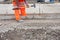 Groundworker making shutter for concrete to form base for kerb using scaffold boards and steel road pins during new road