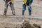 Groundworker placing wet concrete inside formwork during roadworks and new road construction