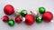 Group of 5 red ornaments with green and gold ornaments with a background of snow