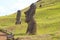 Group of abandoned massive Moai statues scattered on the slope of Rano Raraku volcano, historic Moai quarry on Easter Island