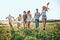 Group of active friends running at picnic lunch on the field