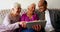 Group of active mixed-race senior friends discussing over digital tablet in nursing home 4k