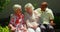 Group of active mixed-race senior friends interacting with each other in the garden of nursing home