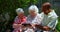 Group of active mixed-race senior friends using digital tablet in the garden of nursing home 4k