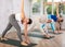 Group of active women practices the Parivritta Trikonasana pose