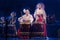 Group of actresses in traditional kimono and fox masks drum taiko drums on the stage